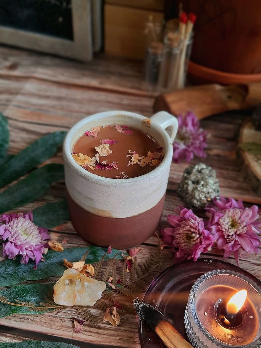 Taza de cacao con flores y pétalos en altar íntimo
